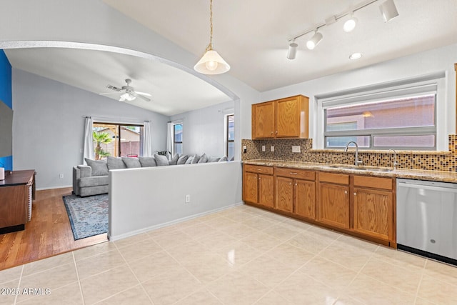 878 E Mountain View Rd, San Tan Valley, AZ 85143 - kitchen featuring dishwasher, vaulted ceiling, arched walkways, brown cabinets, and tasteful backsplash