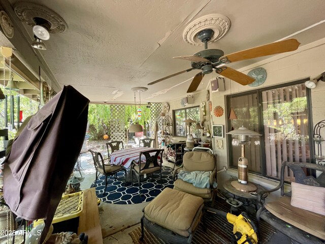 sunroom with a textured ceiling and ceiling fan