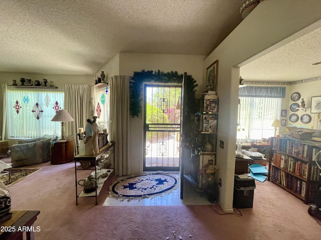 carpeted foyer entrance with a textured ceiling