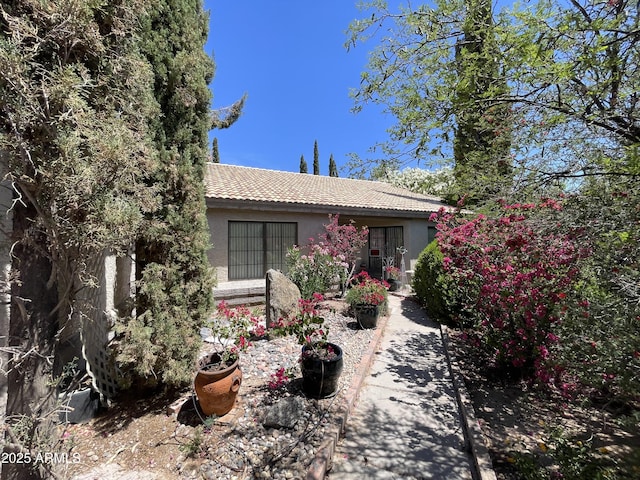 view of front of home featuring a tiled roof and stucco siding