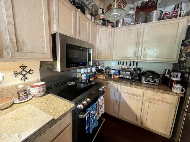 kitchen featuring light brown cabinetry, stainless steel microwave, range with electric cooktop, and light countertops
