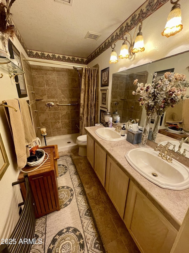 bathroom with a sink, tile patterned flooring, a tile shower, and visible vents