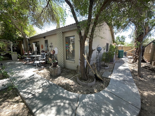 exterior space featuring a patio, concrete block siding, and fence