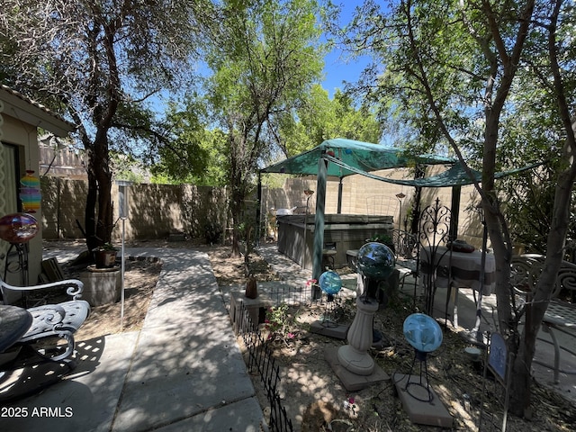 view of patio / terrace featuring a hot tub and a fenced backyard