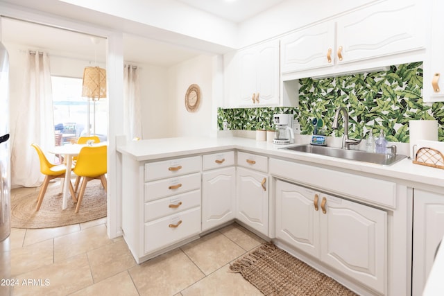 kitchen with white cabinetry, sink, and light tile patterned floors