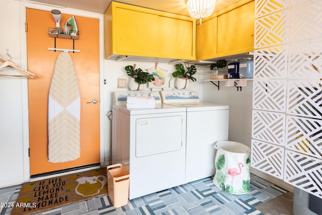 laundry area featuring washer and dryer, cabinets, and an inviting chandelier