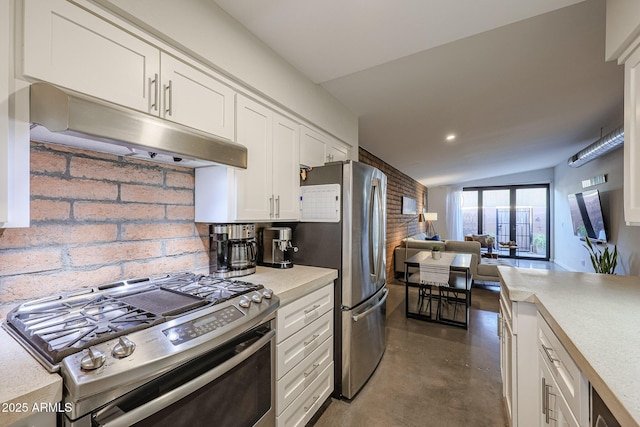 kitchen with stainless steel appliances, tasteful backsplash, lofted ceiling, and white cabinets