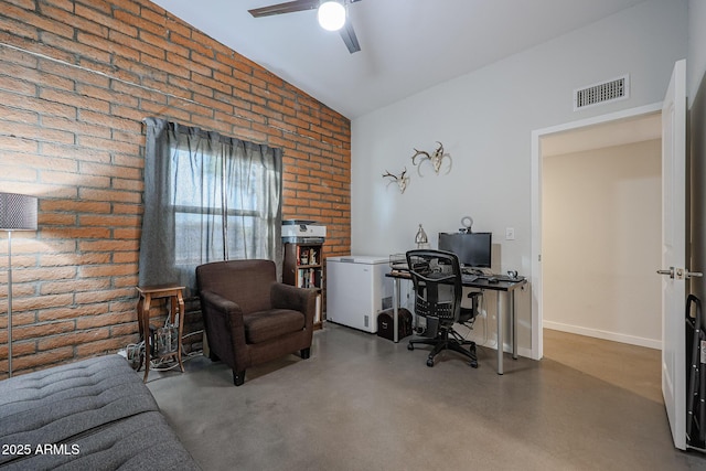 office featuring concrete flooring, vaulted ceiling, brick wall, and ceiling fan