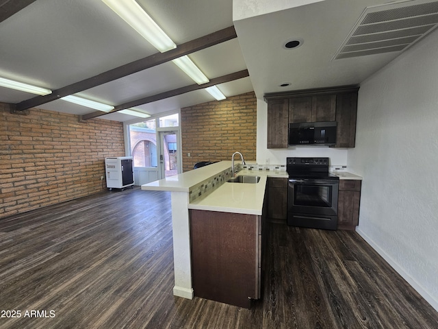 kitchen featuring sink, dark hardwood / wood-style floors, kitchen peninsula, brick wall, and black appliances