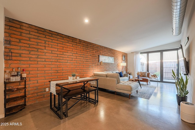 living room featuring brick wall and concrete floors