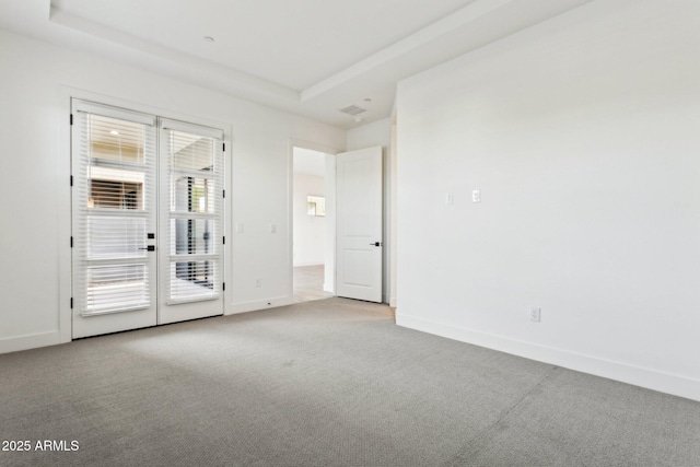 spare room with french doors, baseboards, carpet, and a tray ceiling
