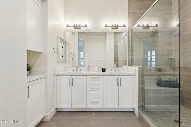 full bath featuring a sink, tile patterned floors, a stall shower, and double vanity