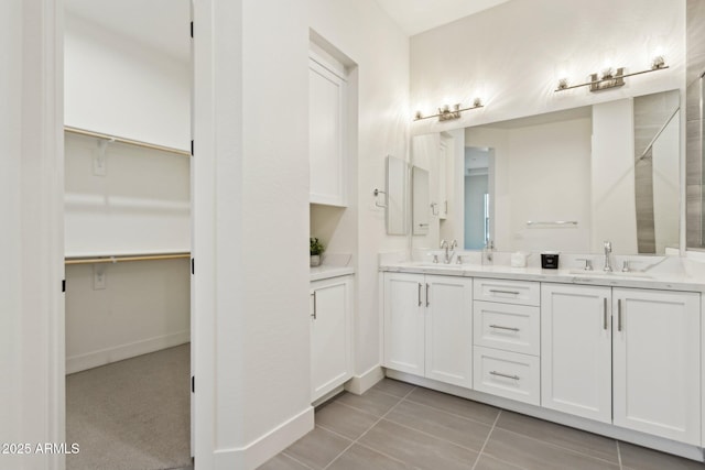 full bath featuring double vanity, a spacious closet, and a sink