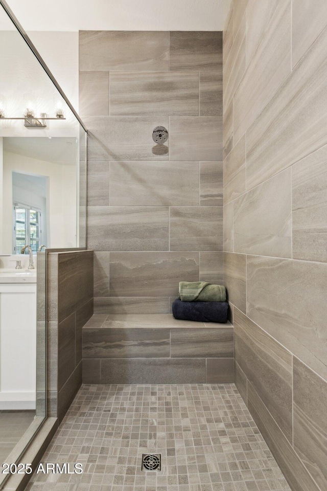 full bath featuring vanity and tiled shower