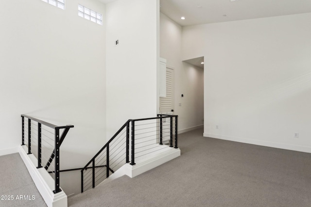 stairs with carpet flooring, recessed lighting, a high ceiling, and baseboards