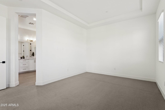unfurnished room with baseboards, a wealth of natural light, light carpet, and visible vents