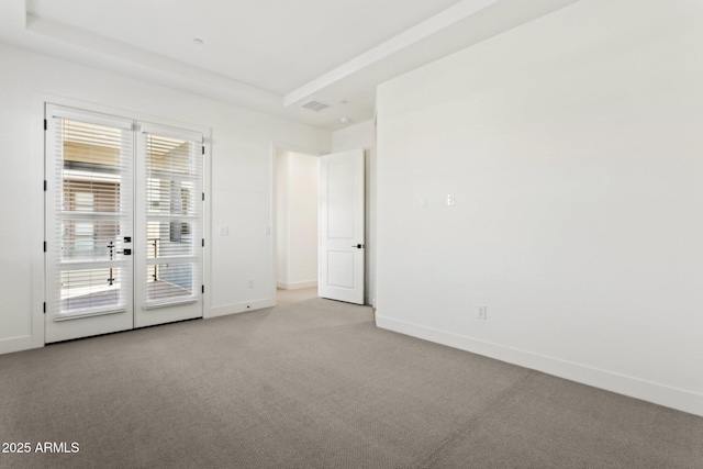 carpeted spare room featuring baseboards and visible vents