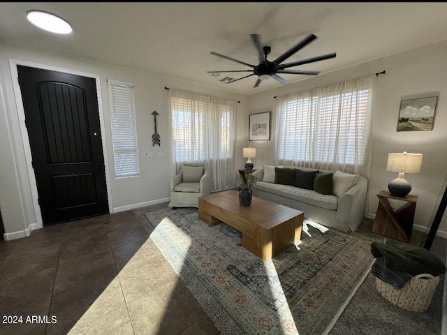 living room with dark tile patterned flooring and ceiling fan