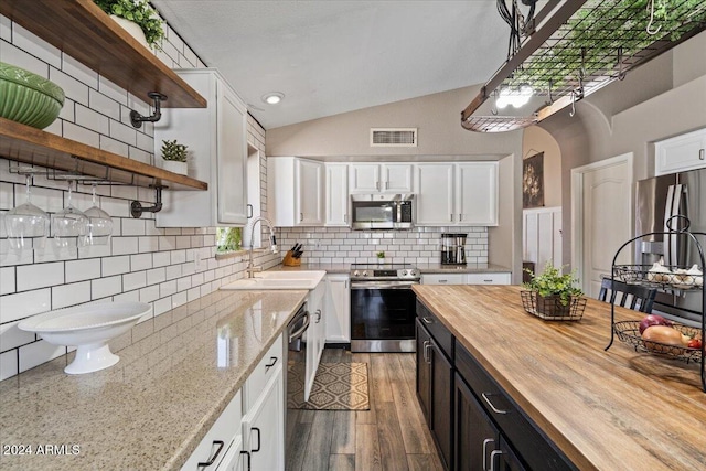 kitchen featuring white cabinets, sink, stainless steel appliances, and wooden counters