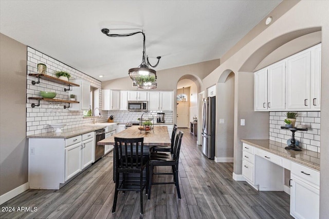 kitchen featuring white cabinetry, pendant lighting, stainless steel appliances, and dark hardwood / wood-style floors