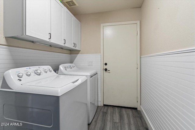 washroom with washer and dryer, dark hardwood / wood-style flooring, and cabinets