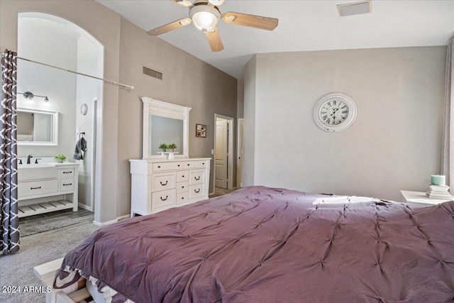 bedroom with light carpet, ensuite bathroom, ceiling fan, and sink