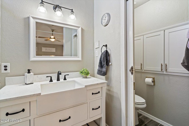 bathroom featuring vanity, ceiling fan, and toilet