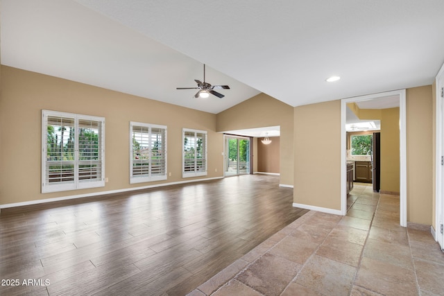2461 Leisure World, Mesa, AZ 85206 - unfurnished living room with baseboards, light wood-type flooring, vaulted ceiling, and ceiling fan with notable chandelier