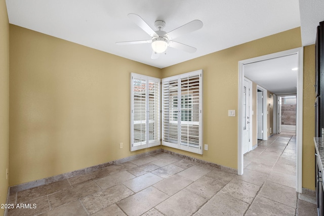 2461 Leisure World, Mesa, AZ 85206 - unfurnished room with baseboards, a ceiling fan, and stone tile floors