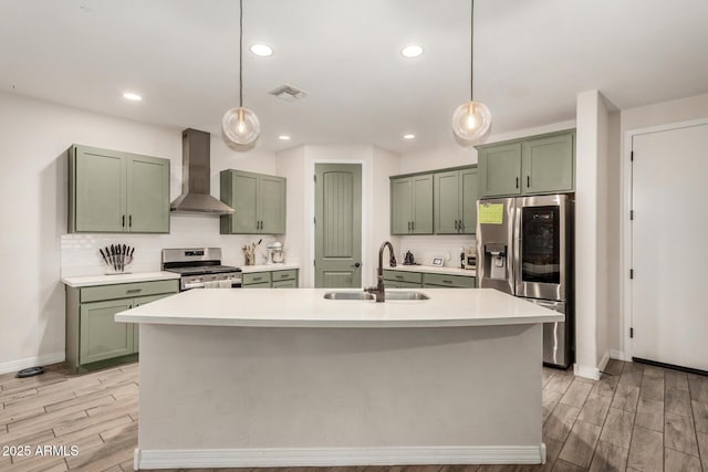 11541 E Corbin Ave, Mesa, AZ 85212 - kitchen with green cabinetry, wall chimney range hood, appliances with stainless steel finishes, a sink, and light wood finished floors