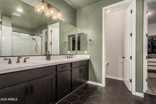 11541 E Corbin Ave, Mesa, AZ 85212 - full bathroom featuring a tile shower, a walk in closet, tile patterned floors, double vanity, and baseboards