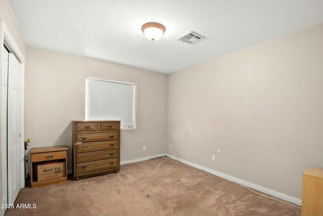 bedroom with light colored carpet, a closet, visible vents, and baseboards