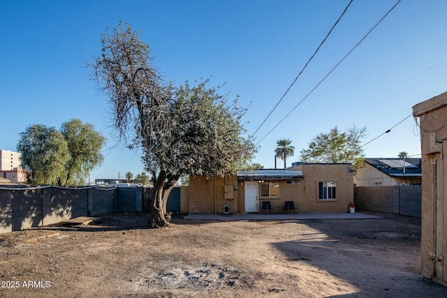 rear view of house with a patio area, a fenced backyard, and stucco siding