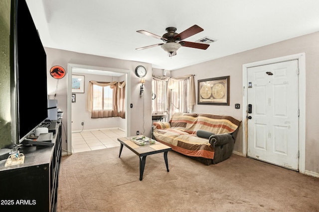 living area with ceiling fan, light tile patterned floors, visible vents, and light colored carpet