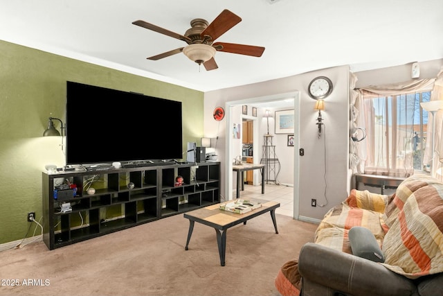 living room featuring ceiling fan, baseboards, and light colored carpet