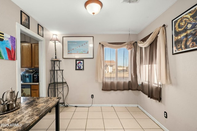 interior space with light tile patterned floors and baseboards