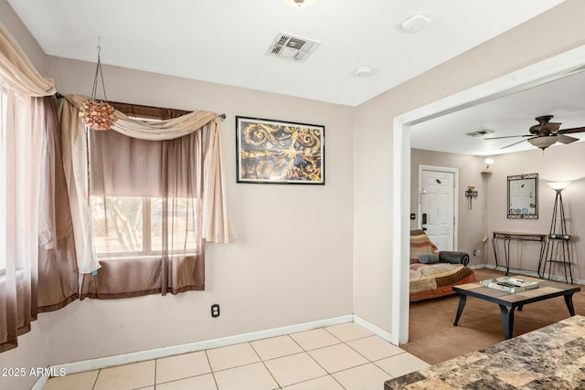 interior space with visible vents, ceiling fan, baseboards, and light tile patterned floors