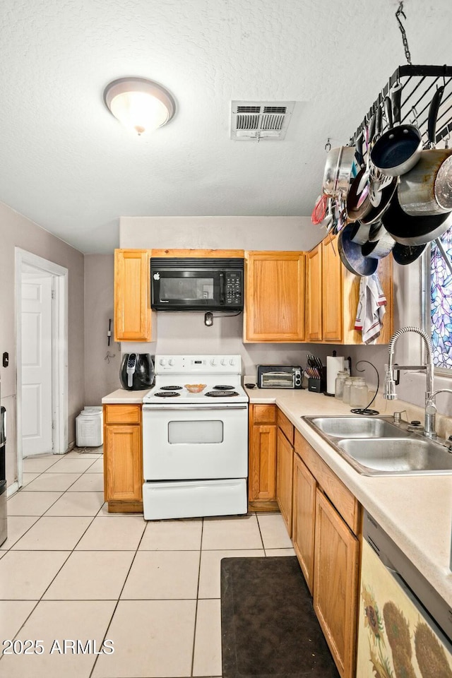 kitchen featuring electric stove, light countertops, stainless steel dishwasher, black microwave, and a sink