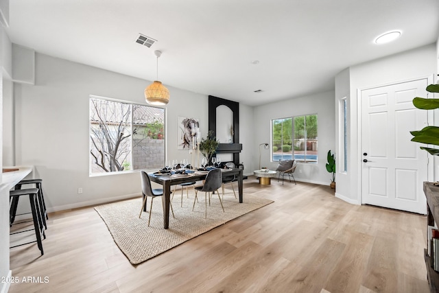 dining space featuring visible vents, light wood-type flooring, and baseboards