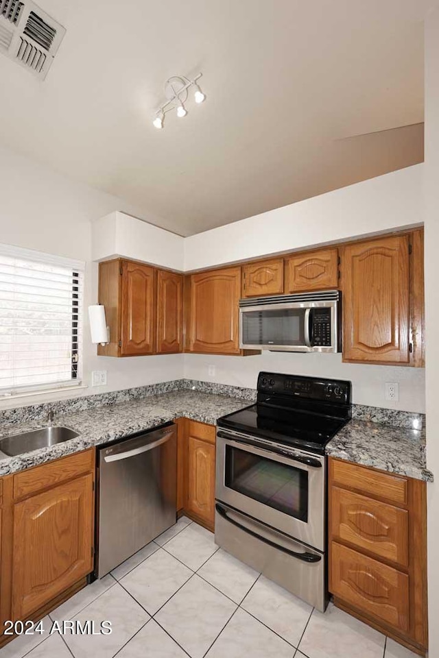 kitchen with light tile patterned flooring, sink, and stainless steel appliances