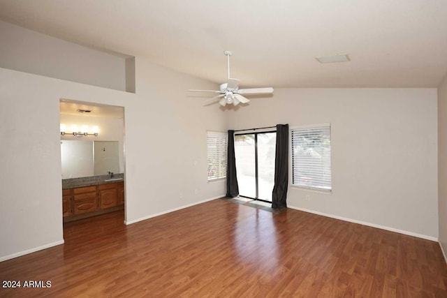 empty room featuring hardwood / wood-style flooring, ceiling fan, lofted ceiling, and sink