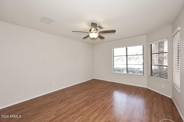 spare room with ceiling fan and dark hardwood / wood-style flooring