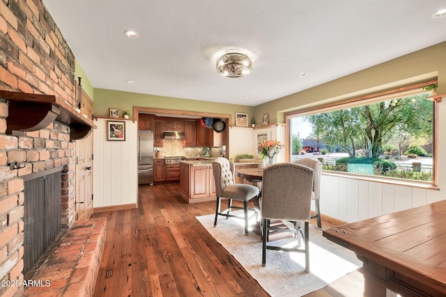 dining space with dark wood-type flooring and a fireplace