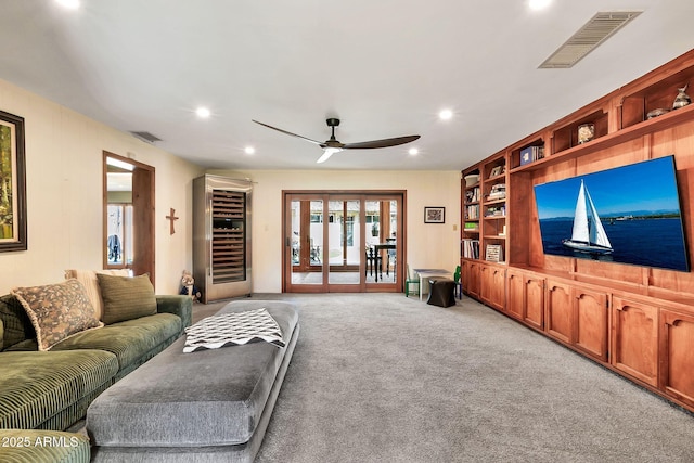 carpeted living room with built in features and ceiling fan