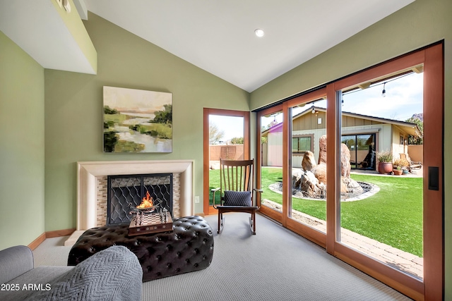 sitting room with light colored carpet, vaulted ceiling, and a brick fireplace