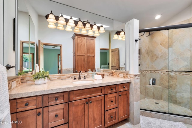 bathroom featuring vanity, backsplash, and a shower with shower door