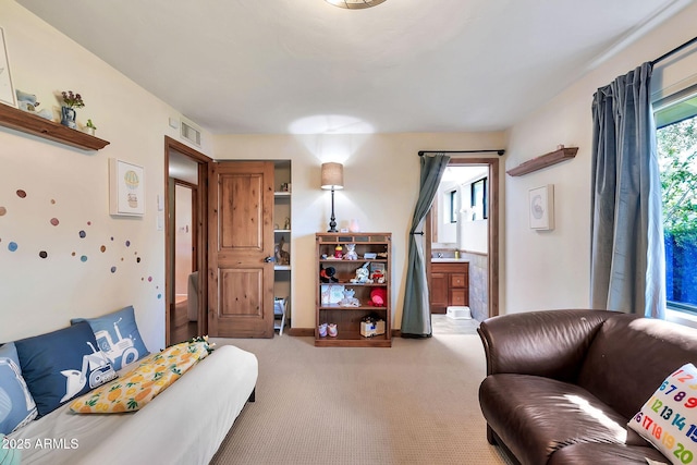 bedroom with light colored carpet and connected bathroom