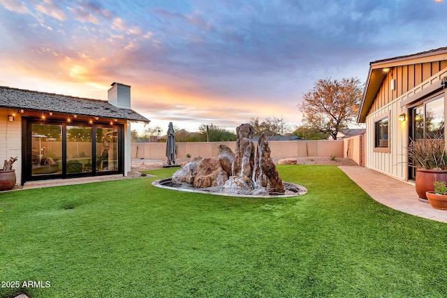 yard at dusk featuring a patio area