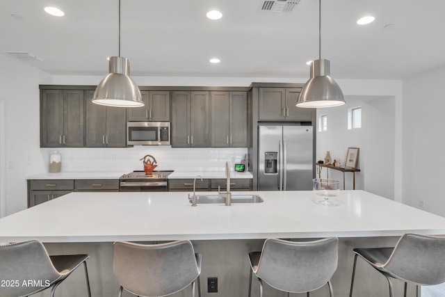 kitchen featuring decorative backsplash, visible vents, a sink, and appliances with stainless steel finishes