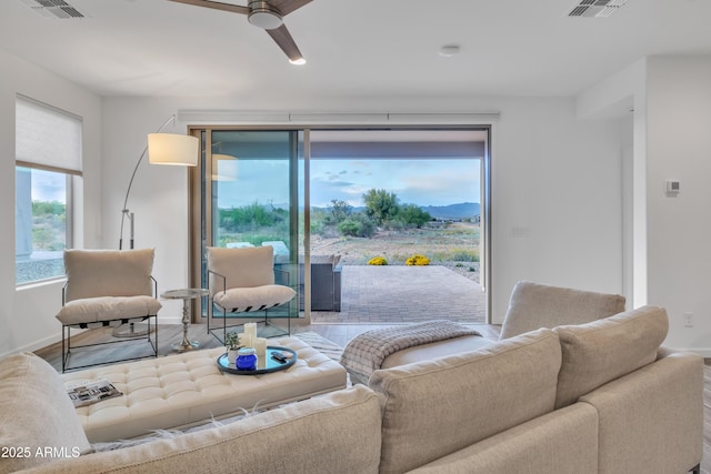 living room with visible vents, ceiling fan, and baseboards